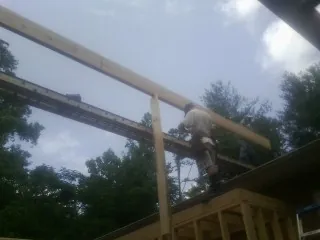 Carpenter setting a ridge beam over a new addition frame — Ice Dam Removal by Roofing Brothers in Eldred