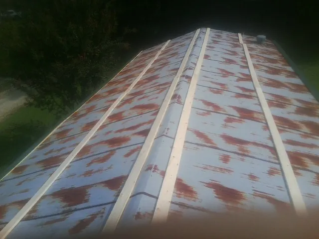 Rusted metal roof panels with new wood purlins before replacement — Storm Damage Roof Repair in Eldred by Roofing Brothers
