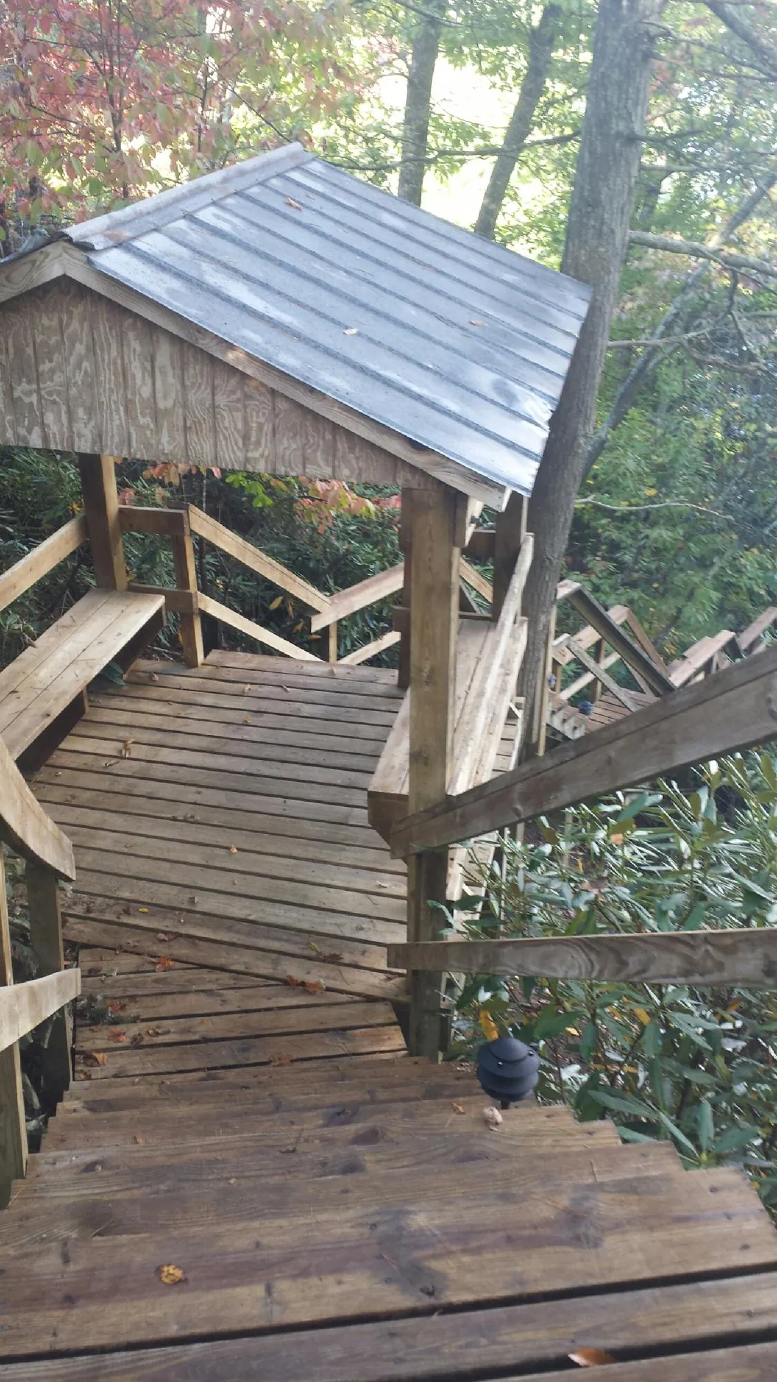 Metal roofed shelter over wooden steps on a wooded walkway — Skylight Repair & Installation work by our crew in Eldred