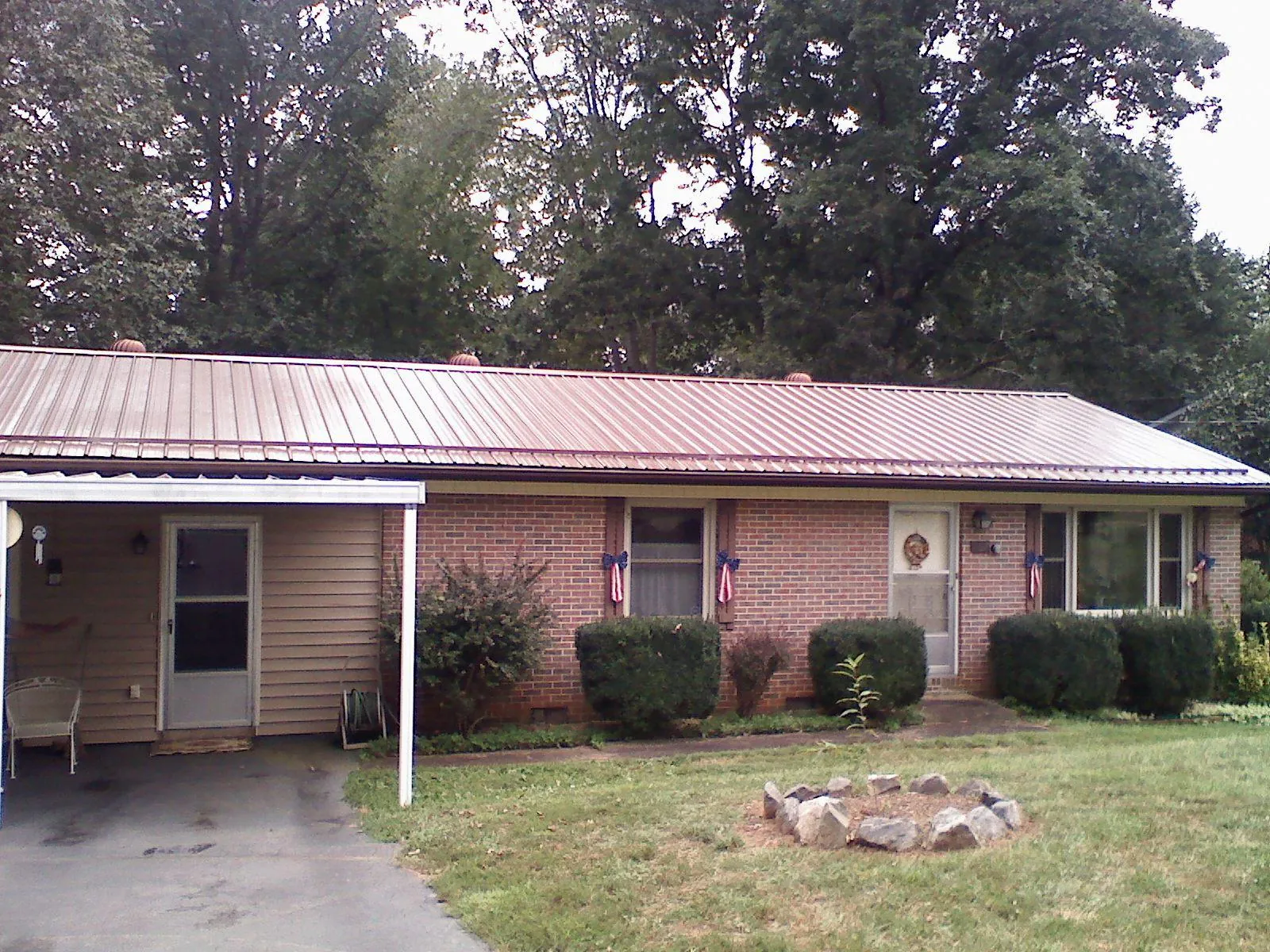 Bronze metal roof and carport on a brick ranch home — Roof Repair work by our crew in Eldred